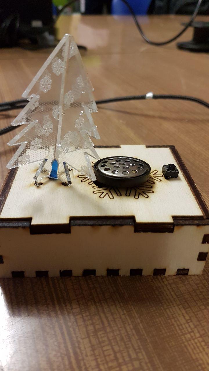 Das fertige, leuchtende "Weihnachtsmelodie"-Projekt: Lasergeschnittene Holzbox mit leuchtender Acryl-Tanne und Lautsprecher