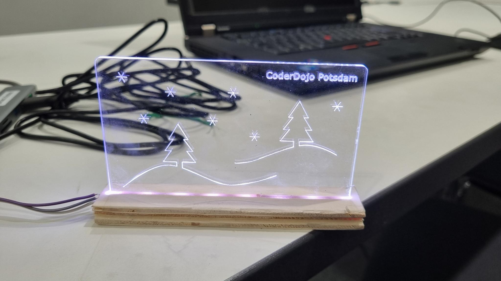 Leuchtendes Acrylglas-Projekt mit "CoderDojo Potsdam"-Gravur und Weihnachtsmotiv bei einem Elektronik-Workshop