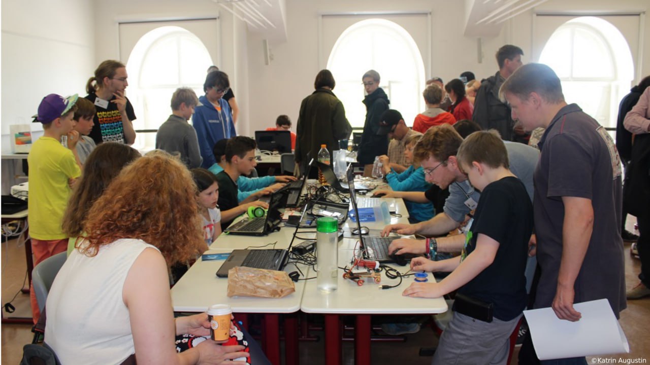 Kinder und Jugendliche programmieren gemeinsam an Laptops
